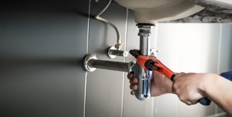 plumber,uses,wrench,to,repair,water,pipe,under,sink,there